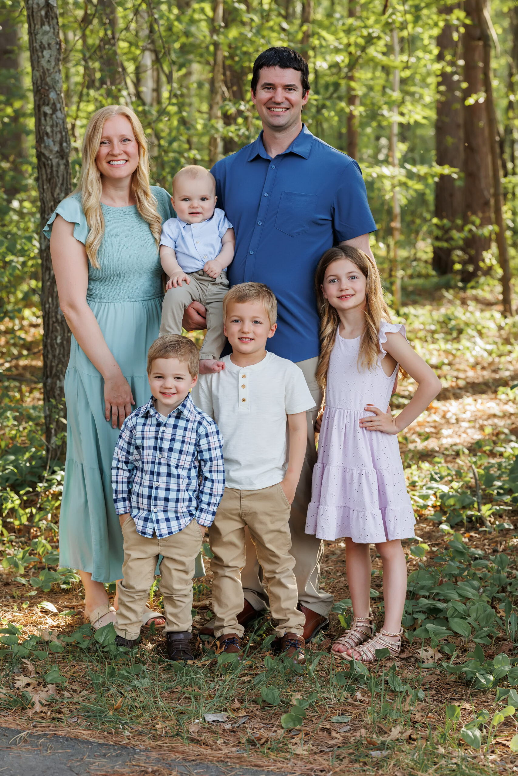 The Dens family, supporters of WonderTrek Children's Museum, posing together outdoors.